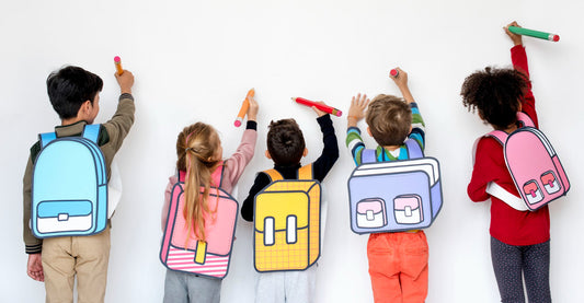 Four children with cartoon-style backpacks drawing on a white wall, representing interactive and creative at-home learning.