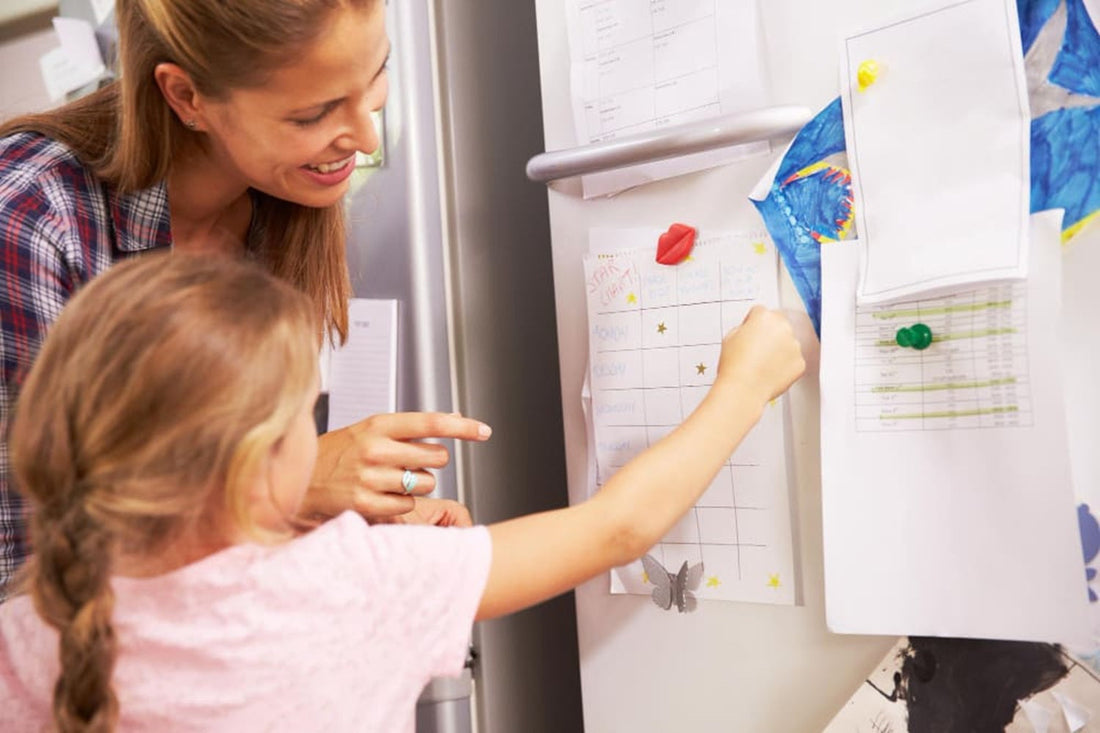 Mother and daughter putting star on reward chart