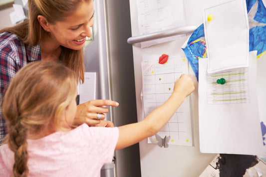 Mother and daughter putting star on reward chart